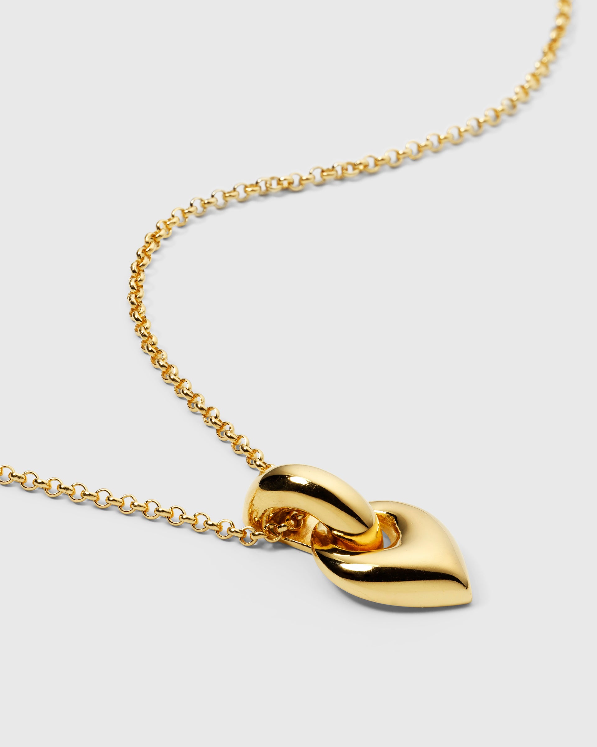 A product shot of the Melinda Long Necklace in gold, featuring its chunky, nature-inspired leaf-shaped pendant on a rolo chain.