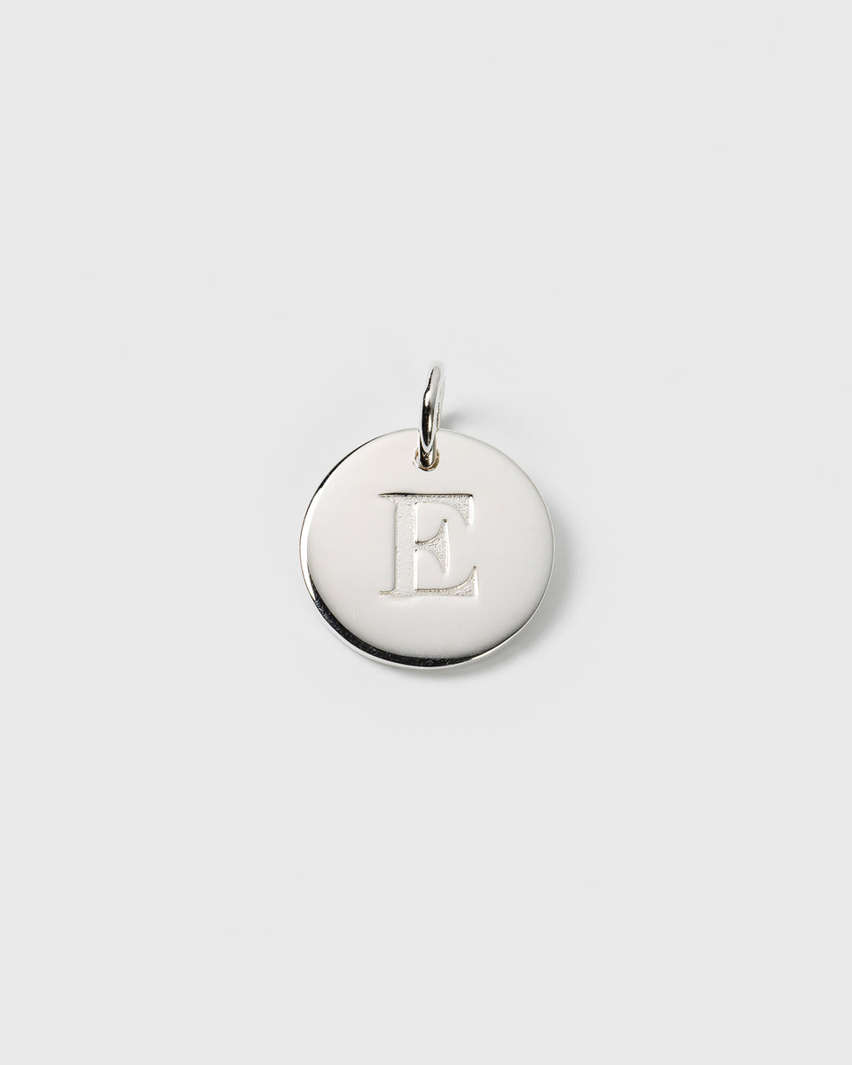 A product shot of the Beloved Big Letter silver charm, featuring a round pendant with the letter 'E' engraved in the center.