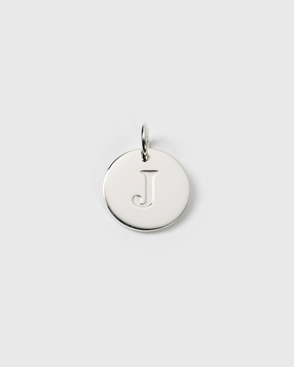 A product shot of the Beloved Big Letter charm in silver, which is a circular pendant with the letter 'J' engraved in the center.