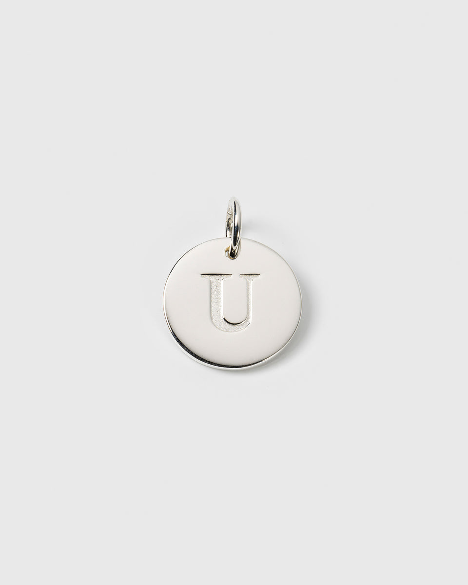 A product shot of the Beloved Big Letter charm in silver, featuring a round pendant with the letter 'U' engraved in the center.
