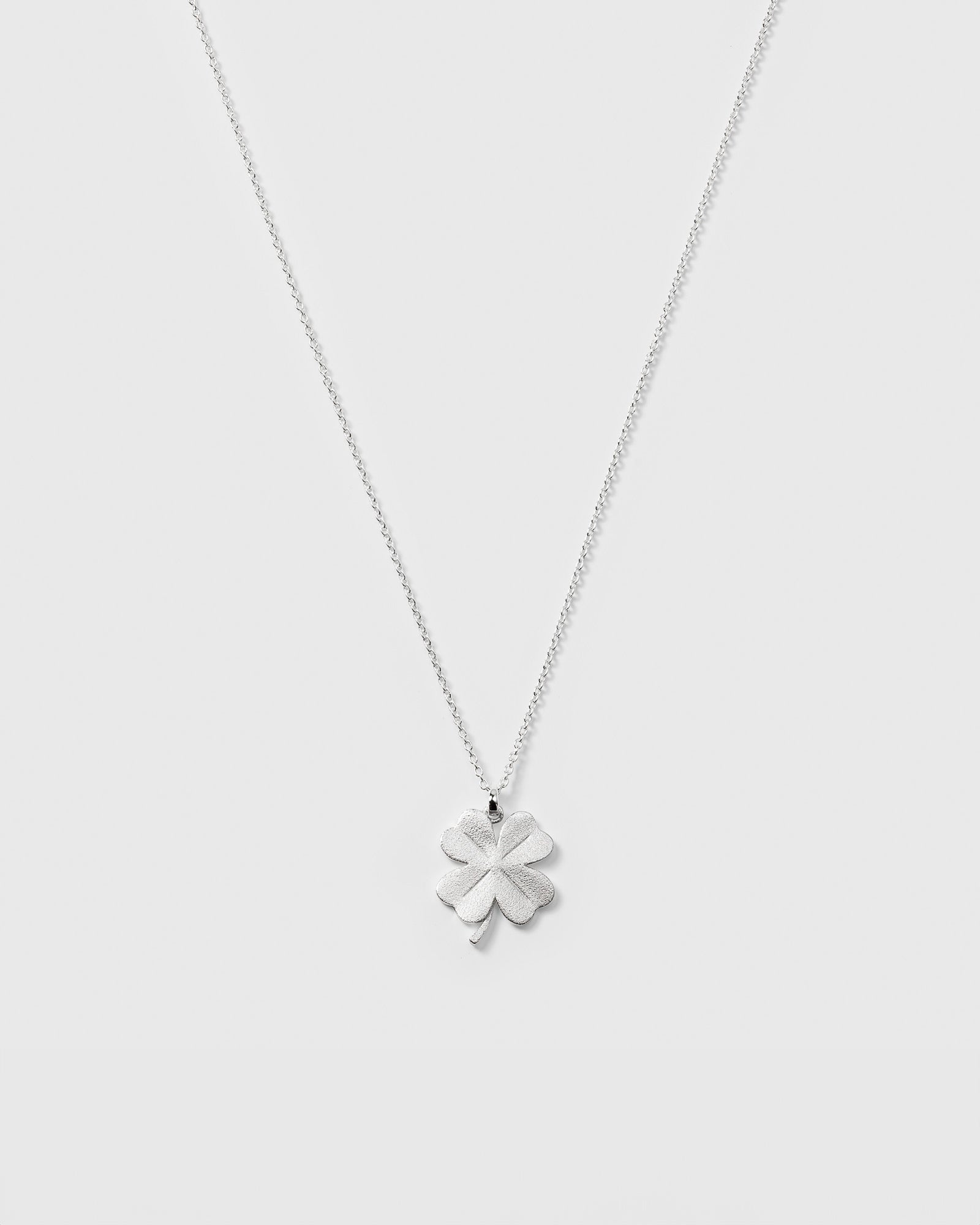 A product shot of the Beaches Fortune Necklace in silver, featuring a fine chain and a four-leaf clover pendant with a matte finish.