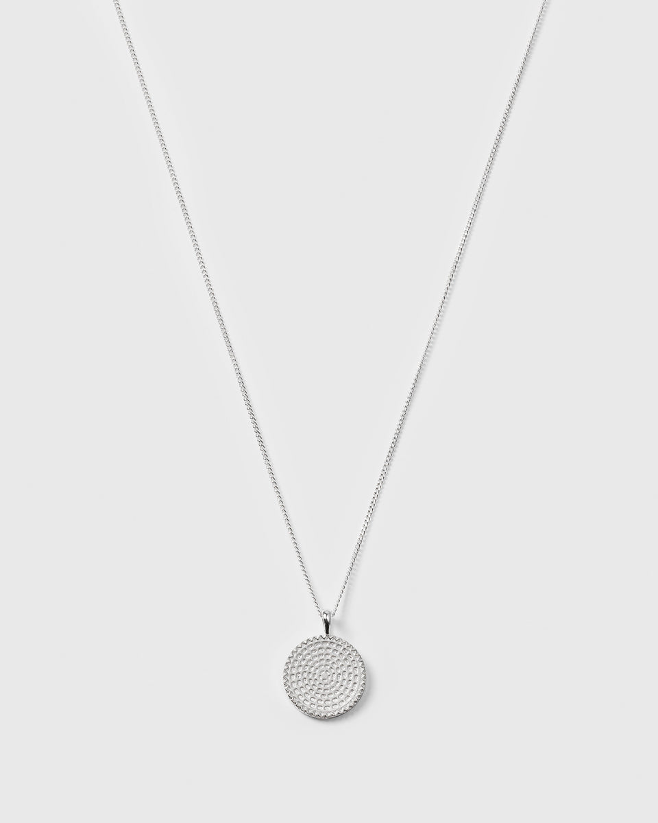 A product shot of the Lucky Coin Heal Necklace in silver, showing its fine chain and the front of the circular pendant which features a detailed sun pattern.