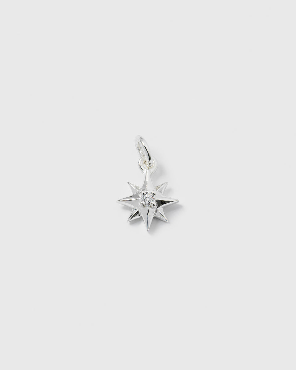 A product shot of the Beloved Compass Star Pendant in silver, featuring a compass star design with a single cubic zirconia set in the center.