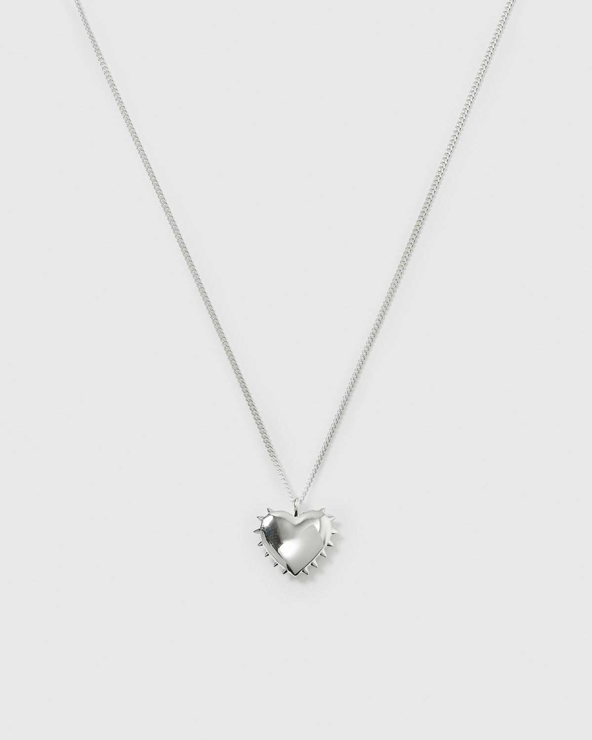 A product shot of the True Love Spike Heart Necklace in silver, showcasing the link chain and the puffy heart pendant adorned with small spikes.