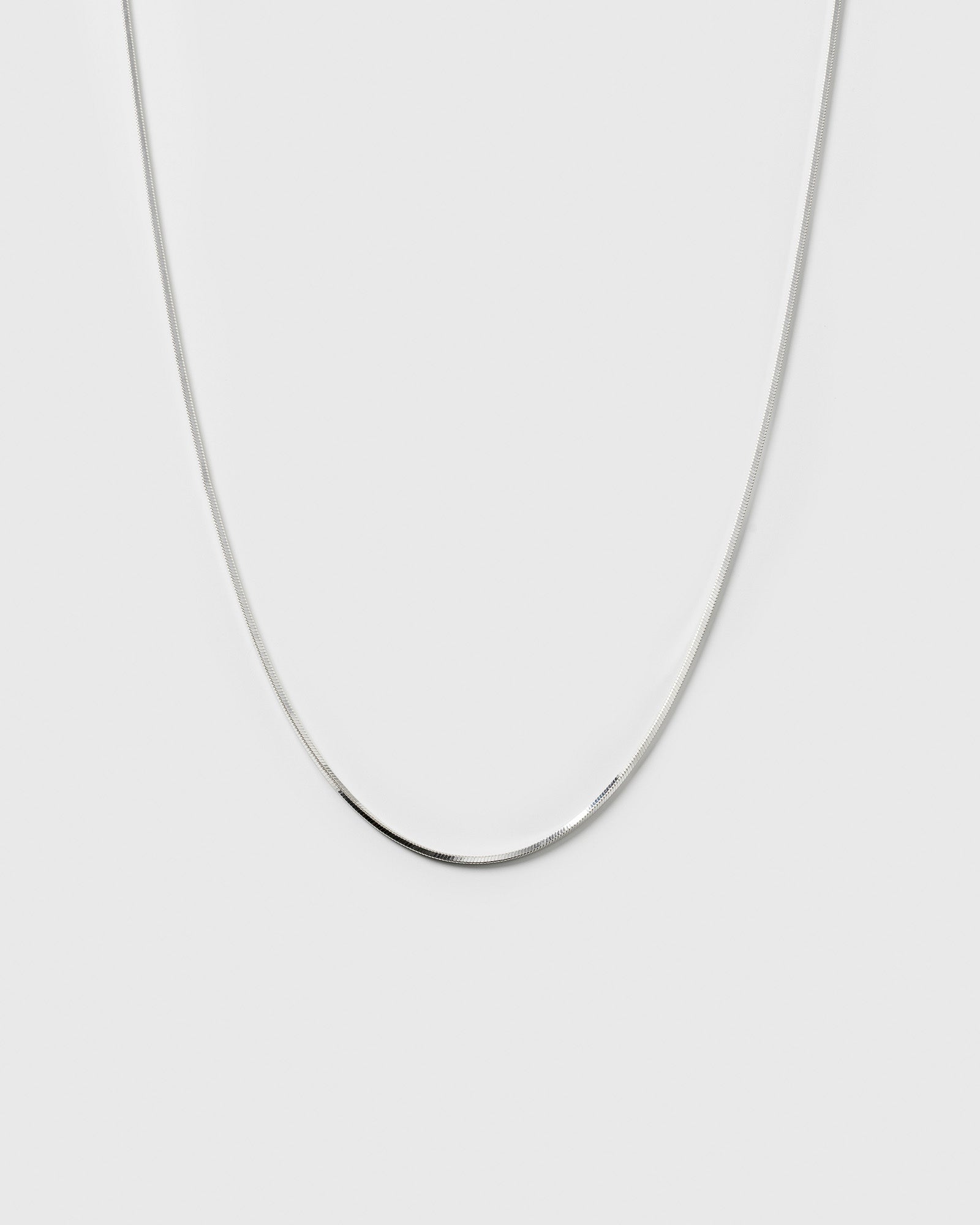 A product shot of the Sheer Mirror Necklace in silver, showcasing its smooth and flat chain design.