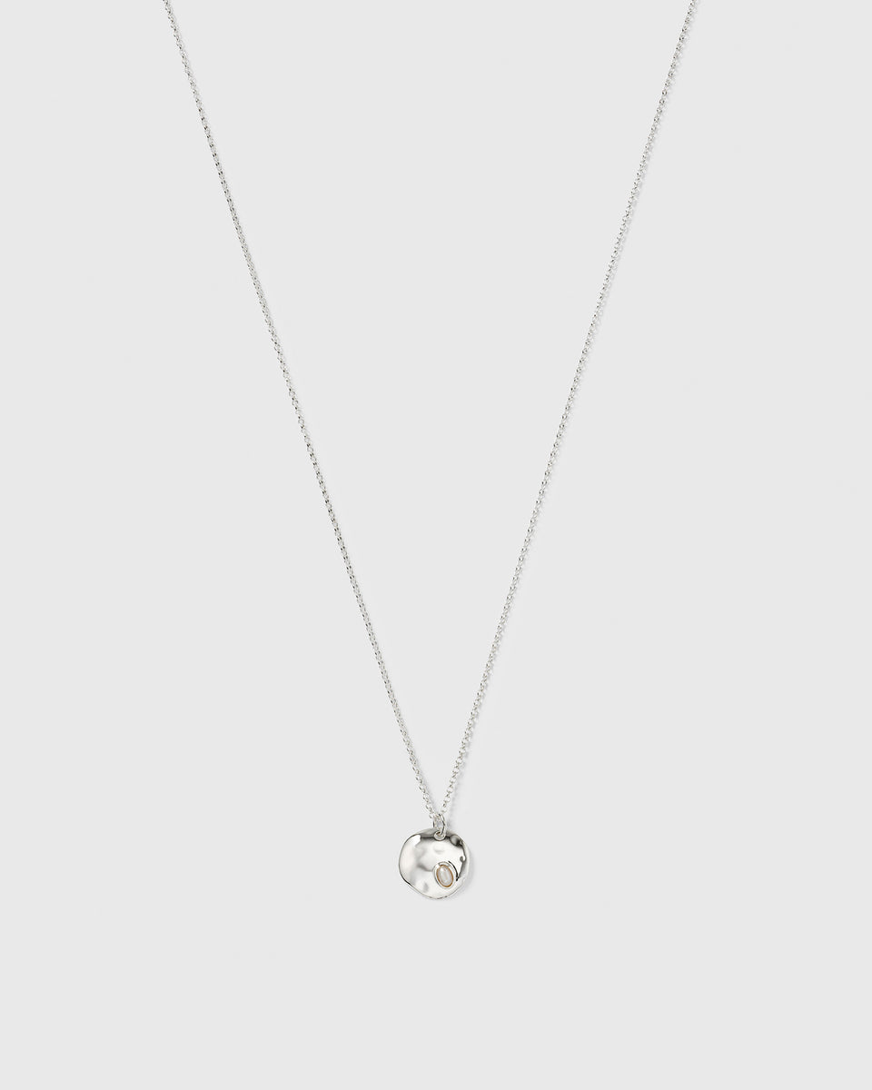 Paxton silver necklace with a fine chain and a hammered pendant holding a baroque freshwater pearl.