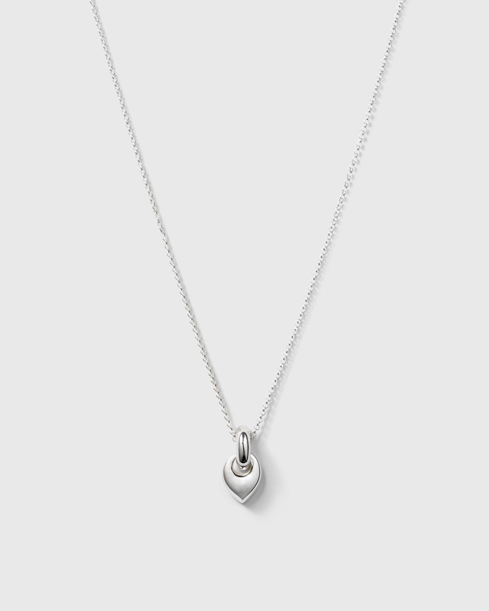 A product shot of the Melinda Long Necklace in silver, featuring a long rolo chain and a chunky, leaf-shaped pendant.