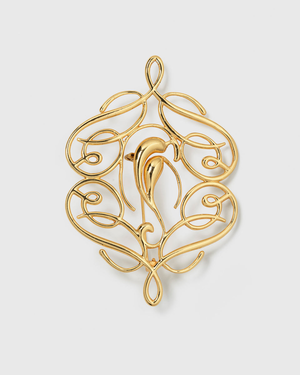 A product shot of the Ophelia Brooch in gold, showcasing its ornate and flowing pattern of intertwined swirls.