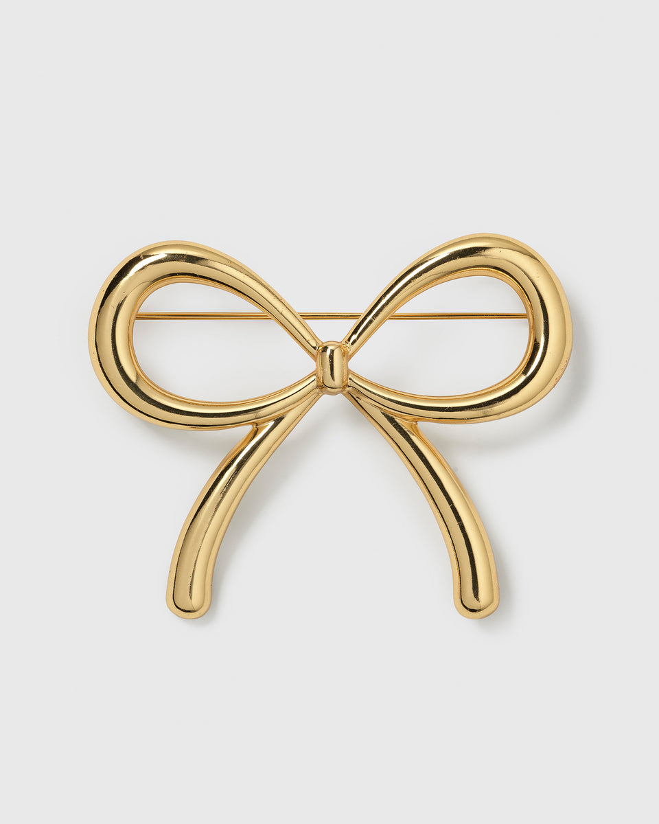 A product shot of the Ana Brooch in gold, highlighting its playful and elegant bow design.