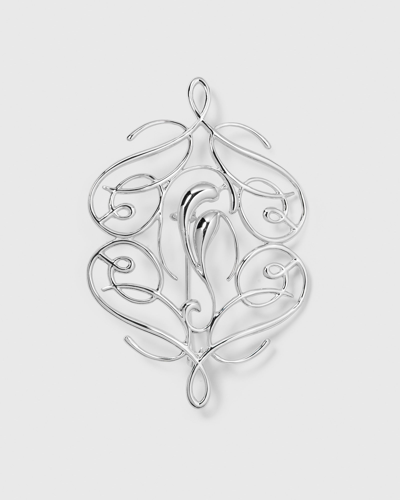A product shot of the Ophelia Brooch in silver, highlighting its intricate and elegant swirling design.