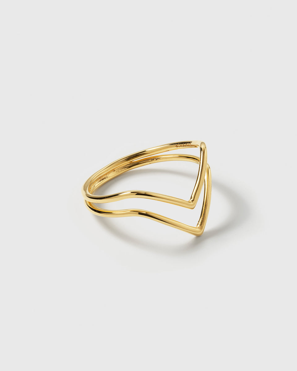 A product shot of the Tiny Arrow Ring in gold, showcasing its delicate design of two bands forming a double arrow.