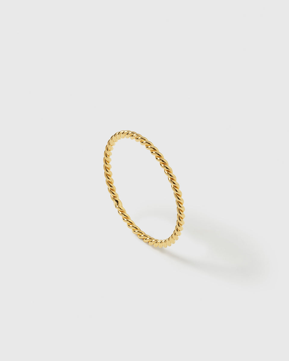 A product shot of the Tiny Twisted Ring in gold, highlighting its delicate twisted design.