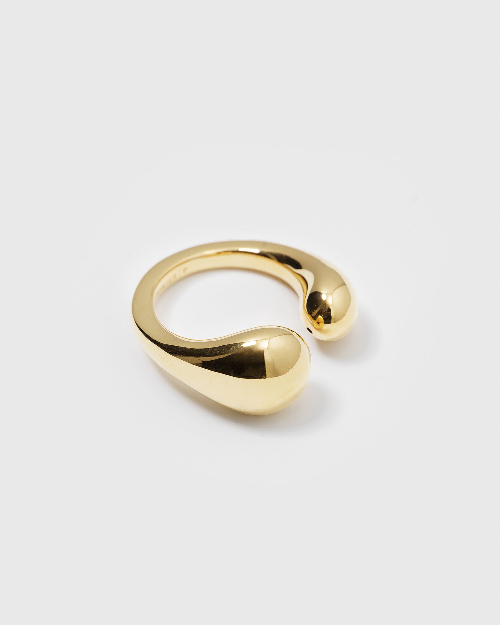 A product shot of the Bolded Drops Ring in gold, an open ring with a bold design featuring two teardrop-shaped ends.