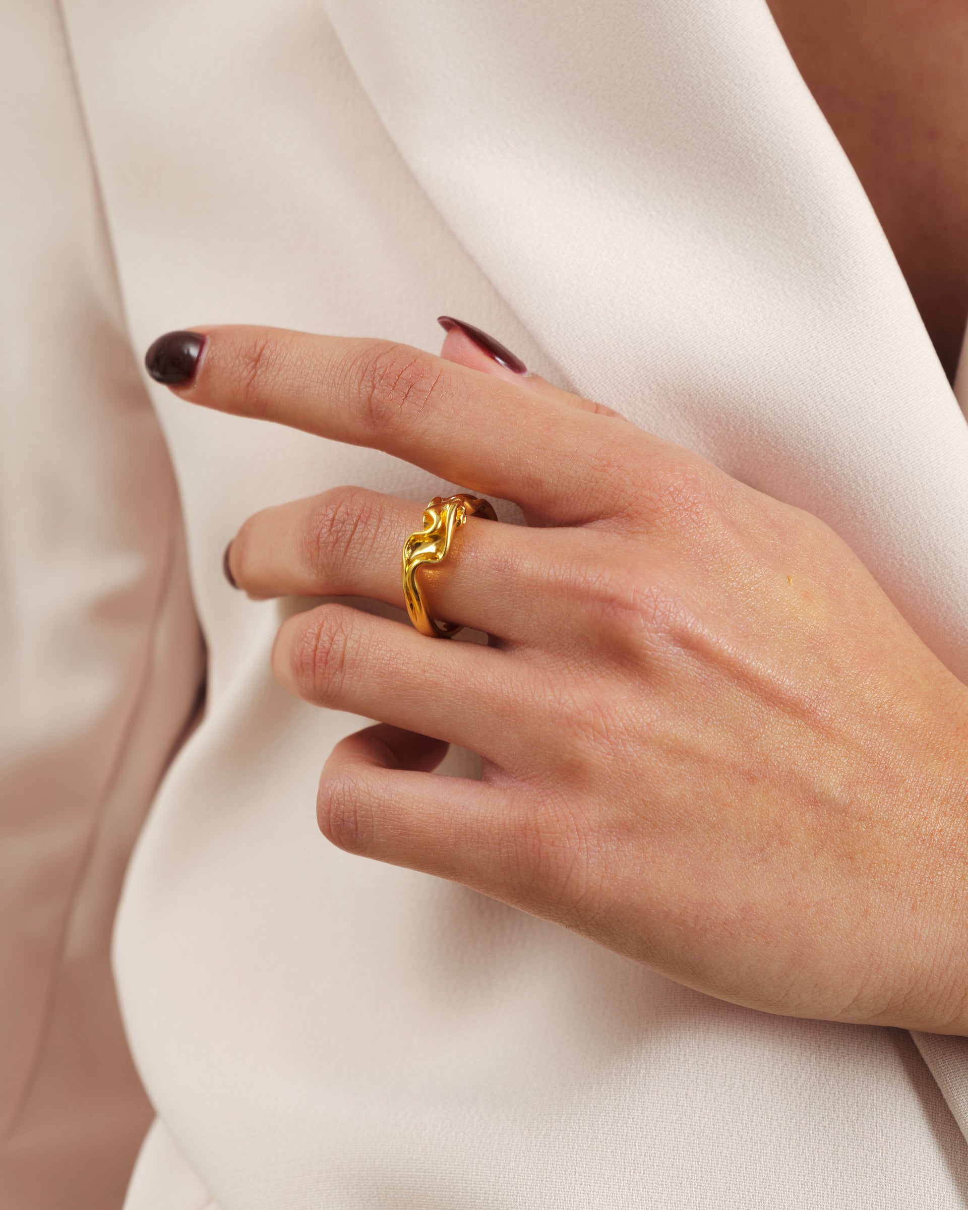 A close-up shot of a model wearing the Moulded Narrow Ring Gold, highlighting its unique organic and wavy shape.