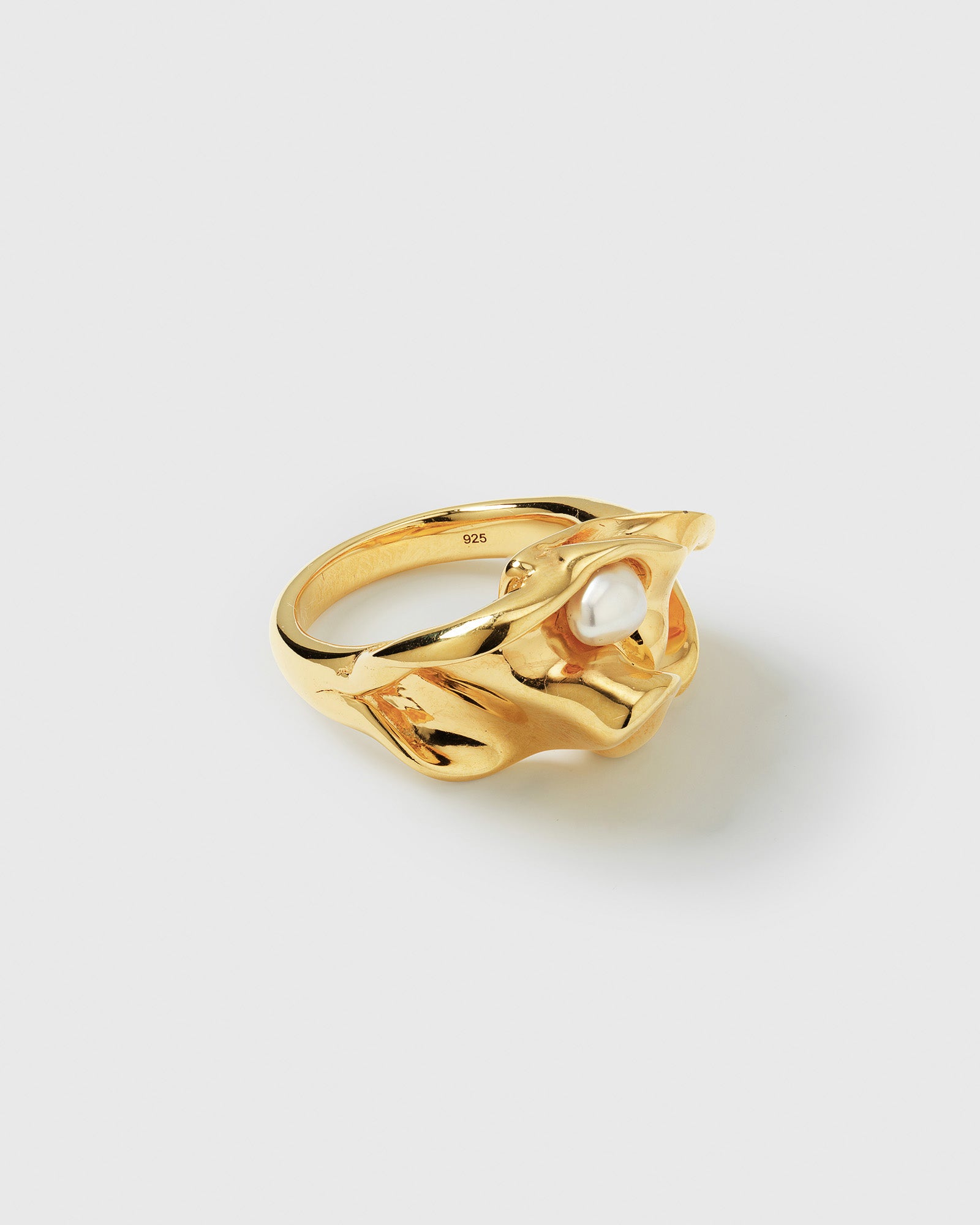 A product shot of the Moulded Big Ring in gold, showcasing its organic, irregular shape inspired by nature, with a single freshwater pearl embedded in the design.