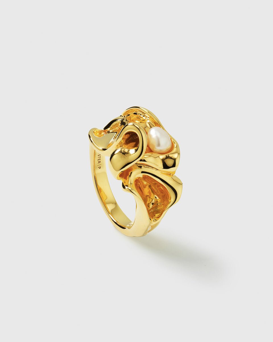 A product shot of the Moulded Big Ring in gold, showcasing its irregular, organic shape and a single freshwater pearl set into the band.