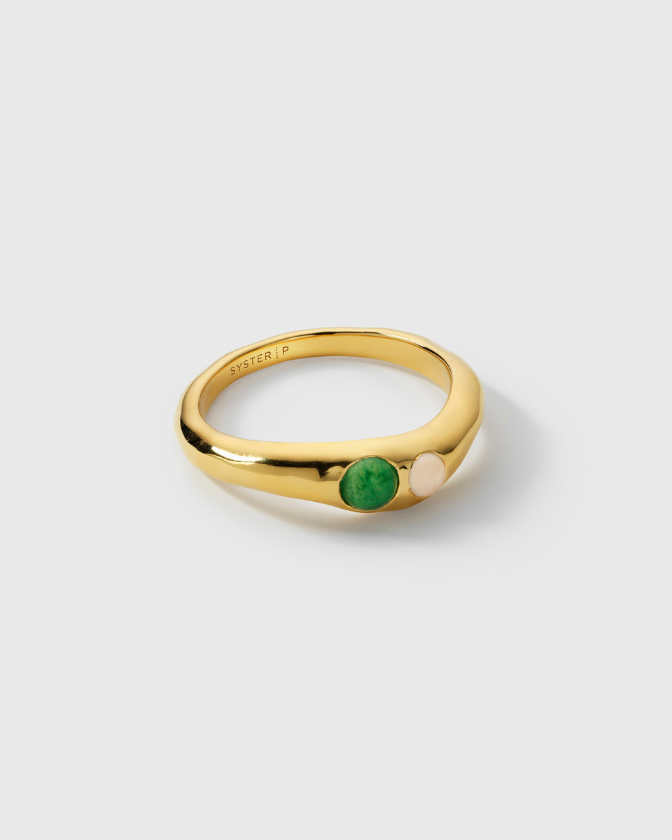 A product shot of the Florentina Ring in gold, showcasing its wavy surface and two inset stones, a green jade and a moonstone.