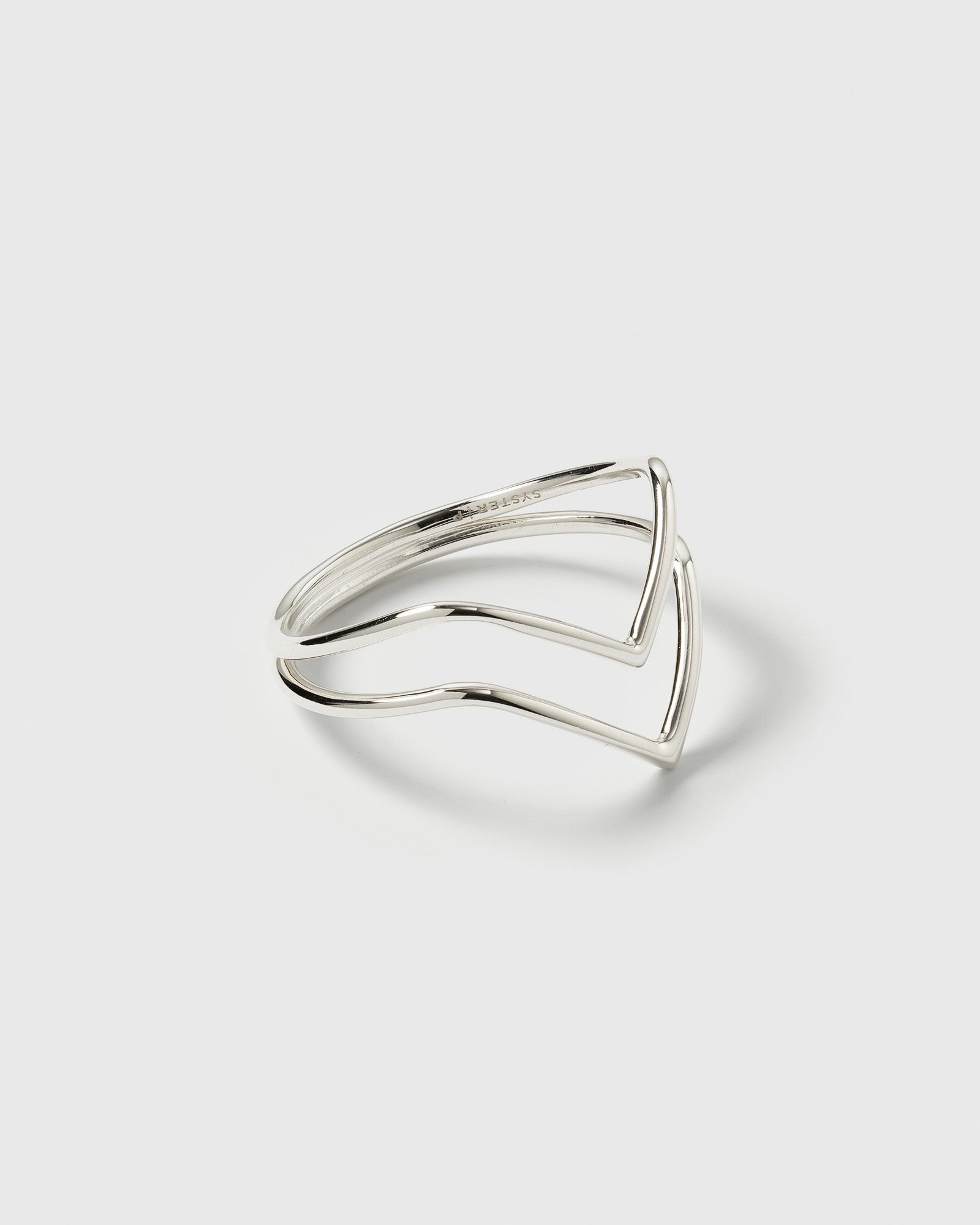 A product shot of the Tiny Arrow Ring in silver, featuring its delicate double-band that forms two opposing arrow shapes.