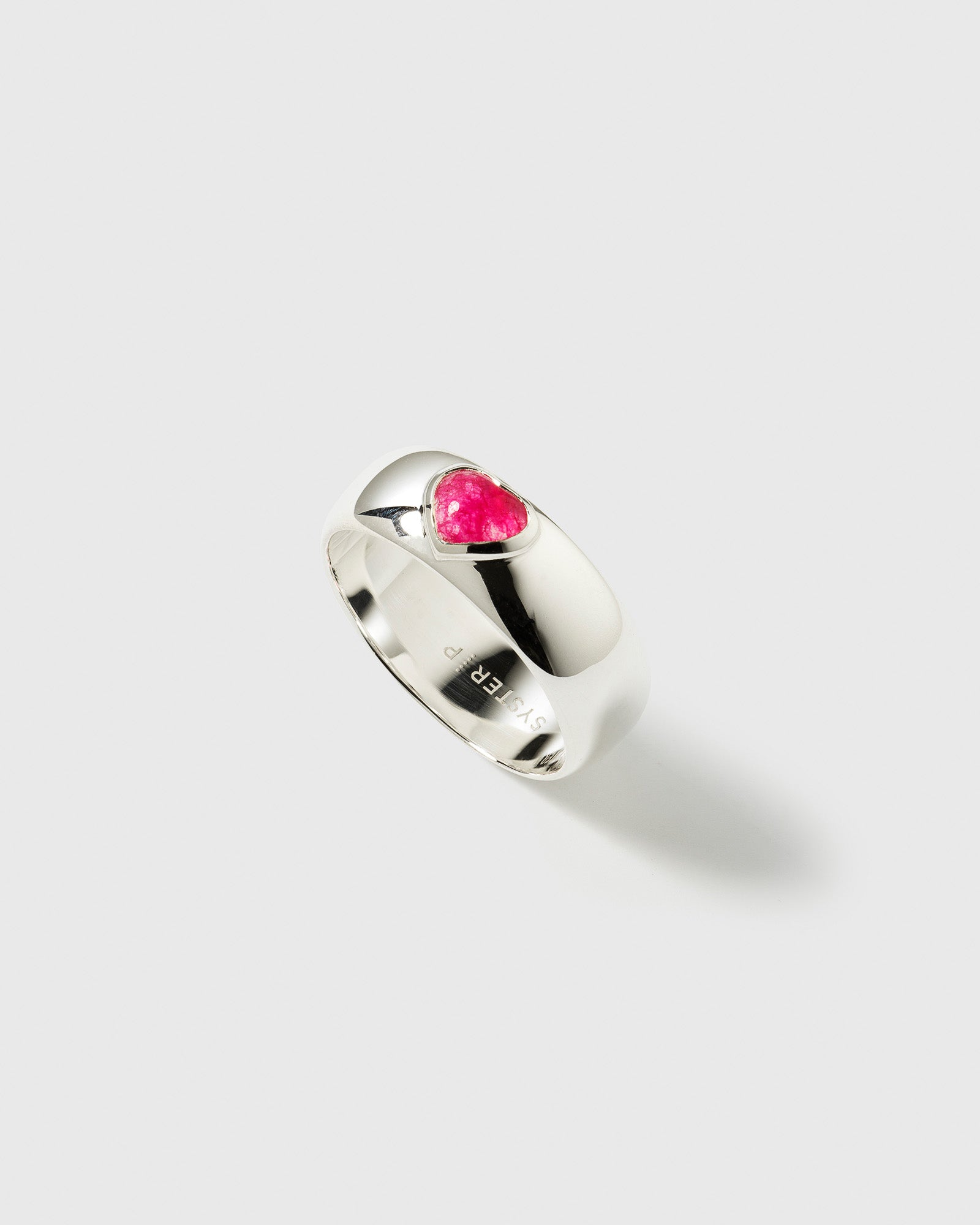 Close-up of the La La Love ring in polished sterling silver, featuring a chunky band with an inset heart-shaped pink quartz stone.