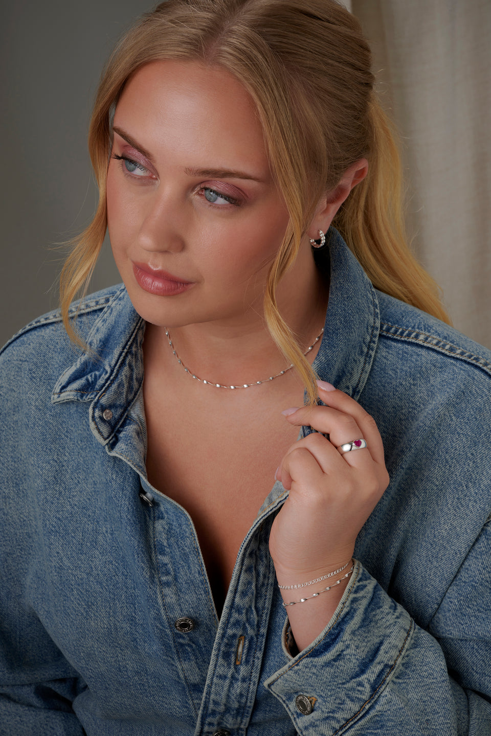 A model wears the La La Love Ring, a chunky recycled sterling silver band featuring a vibrant pink quartz heart.