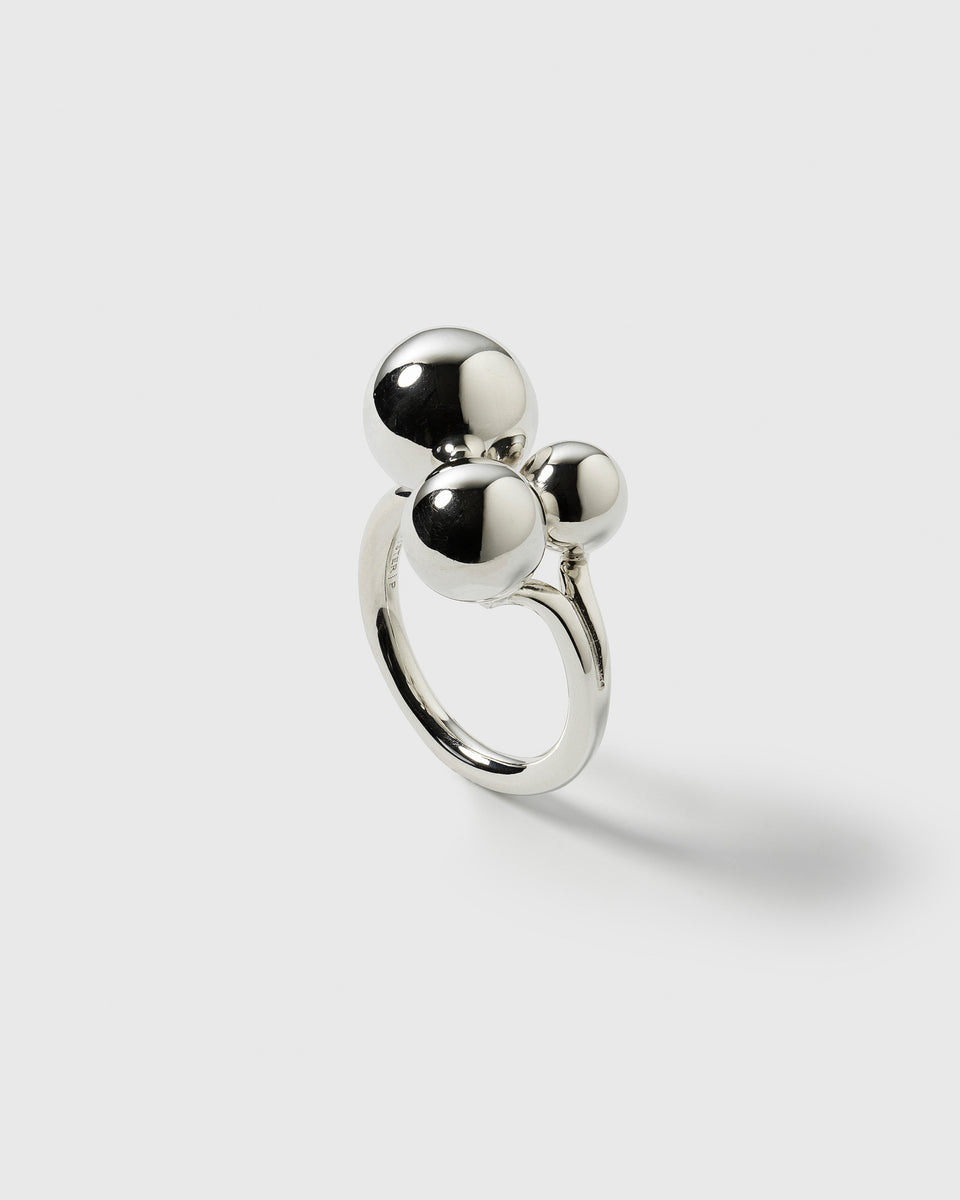 A product shot of the Universe Ring Silver, showcasing its bold design with three polished spheres of varying sizes on a simple band.
