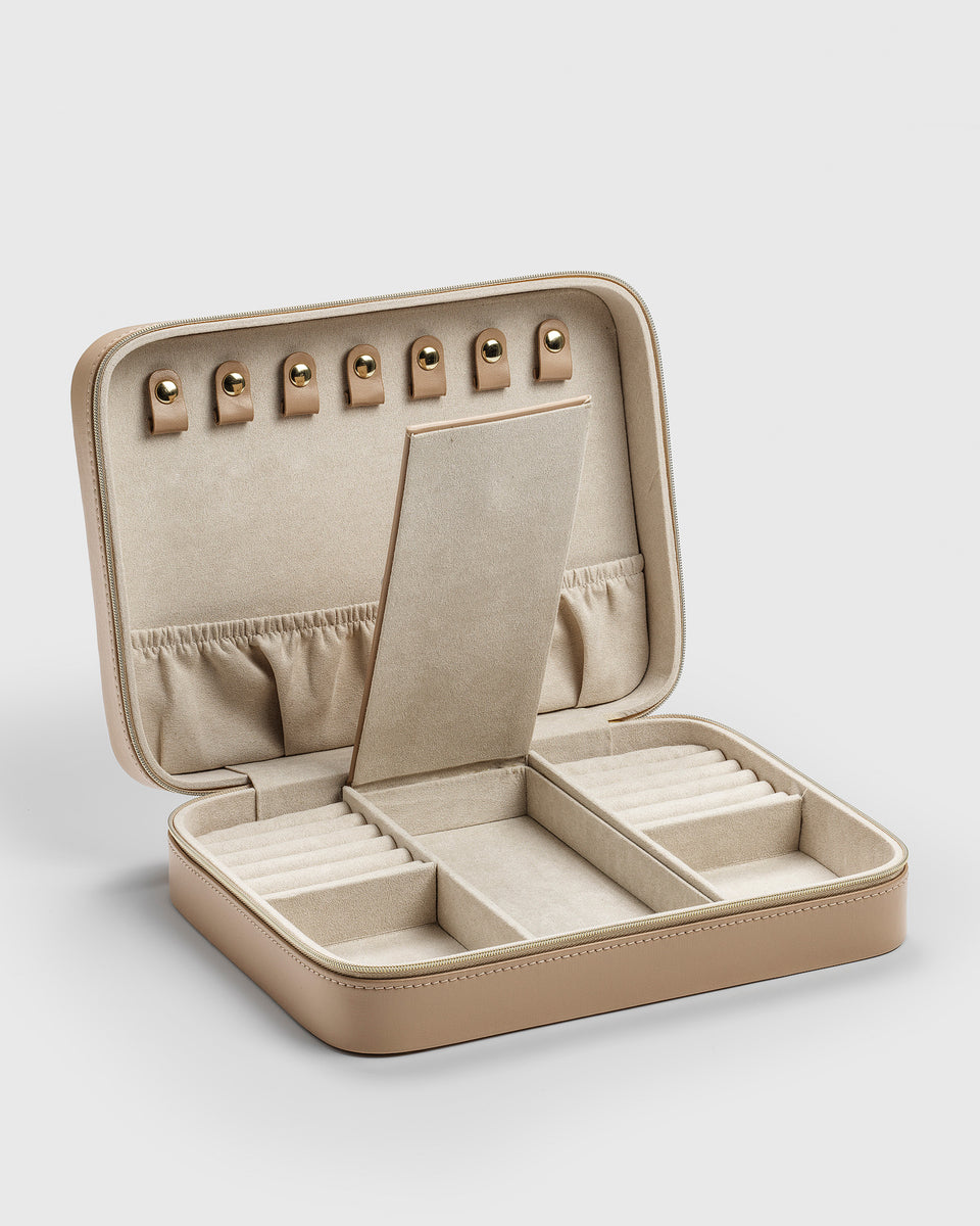 A product shot of the Jewelry Case Large in beige, shown open to reveal its soft interior with multiple compartments designed for organizing necklaces, rings, and other jewelry.