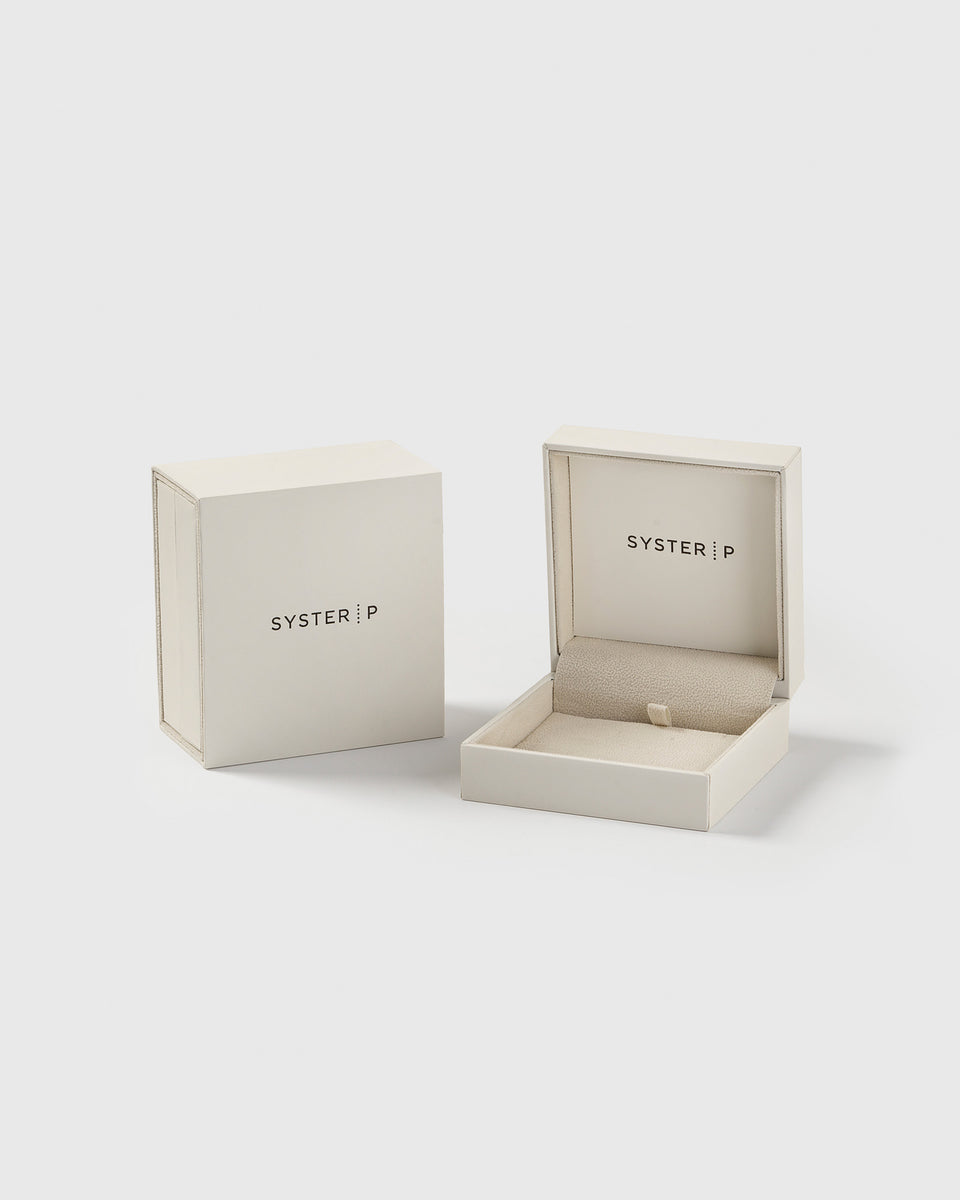 A product shot of the exclusive Syster P jewelry box for the Juno Long Single Earring Silver, shown open with its lid placed beside it.