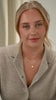 A model wearing the Solea Necklace Gold, which has a delicate chain adorned with small hammered gold circles, layered with another gold necklace featuring a round hammered pendant.